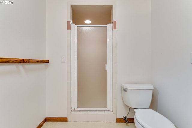 bathroom featuring an enclosed shower and toilet