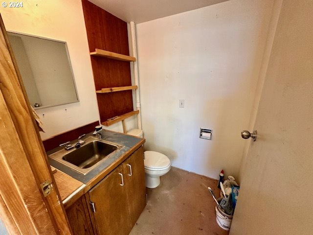 bathroom with vanity, concrete floors, and toilet