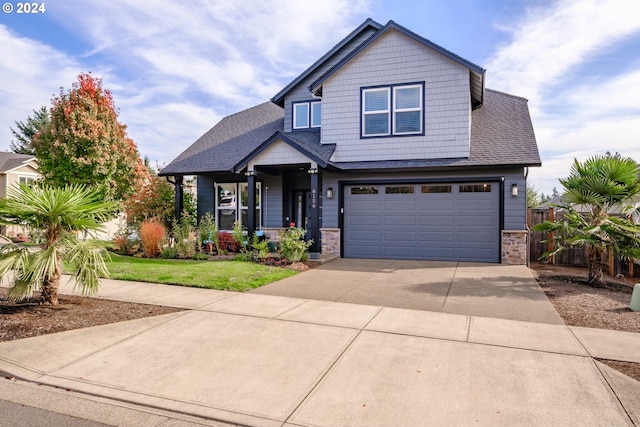 craftsman inspired home with a garage and a front lawn