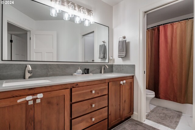 bathroom with vanity, toilet, and backsplash