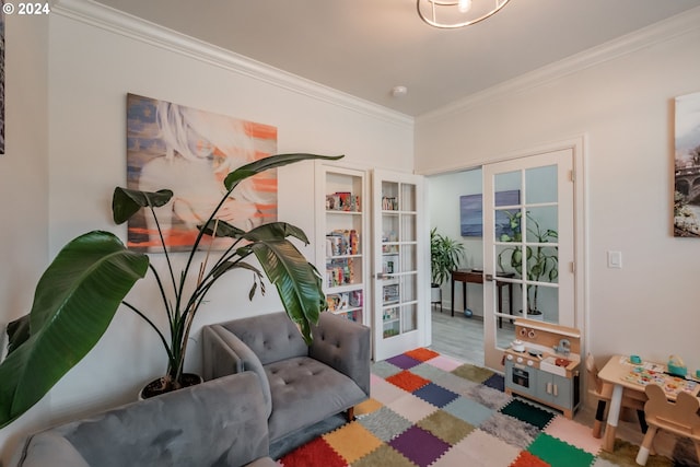 living area with light wood-type flooring, ornamental molding, and french doors