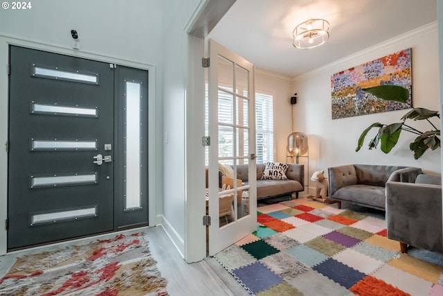 foyer featuring hardwood / wood-style floors and crown molding