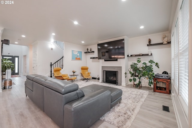 living room featuring light hardwood / wood-style floors and ornamental molding