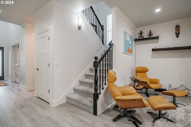 stairway featuring hardwood / wood-style floors and ornamental molding