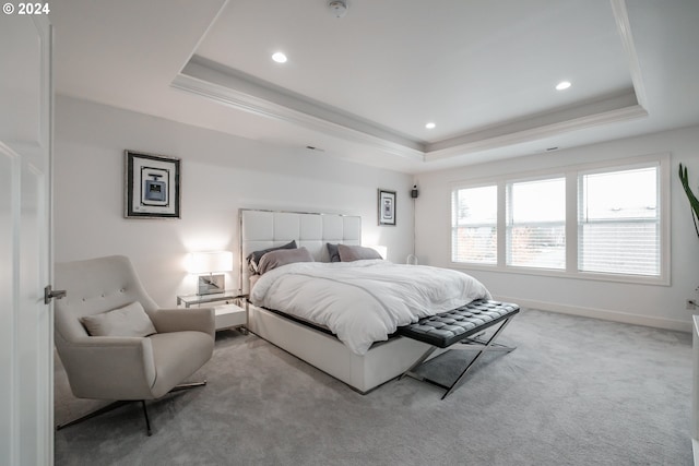 carpeted bedroom featuring a tray ceiling and ornamental molding