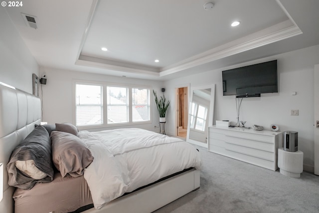 carpeted bedroom featuring a raised ceiling and crown molding