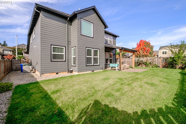 rear view of house with a patio, cooling unit, and a lawn