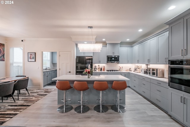 kitchen featuring pendant lighting, a center island, gray cabinetry, and stainless steel appliances