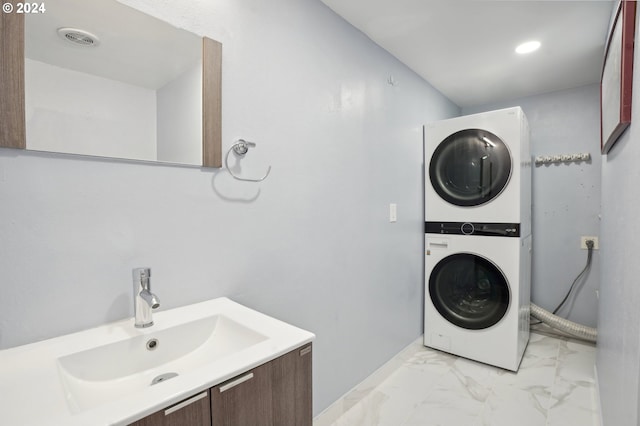 laundry room featuring sink and stacked washer / drying machine