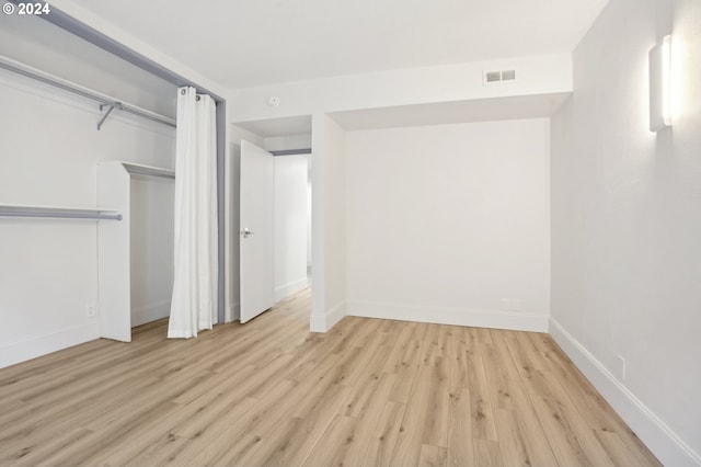 unfurnished bedroom featuring light hardwood / wood-style floors and a closet