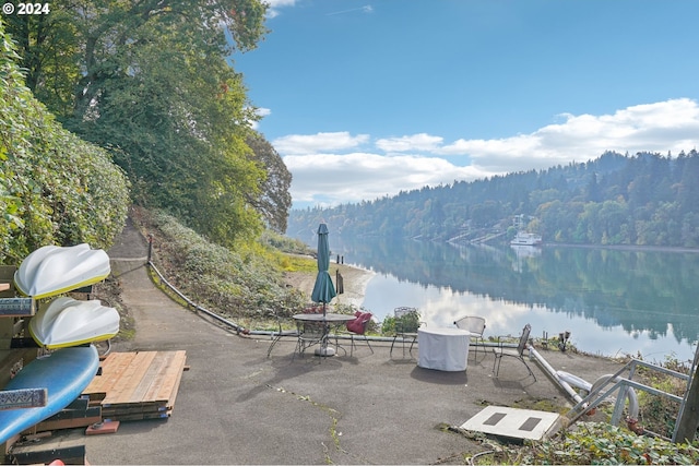 view of patio with a grill and a water view