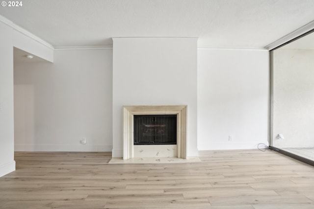 unfurnished living room with light hardwood / wood-style flooring and ornamental molding