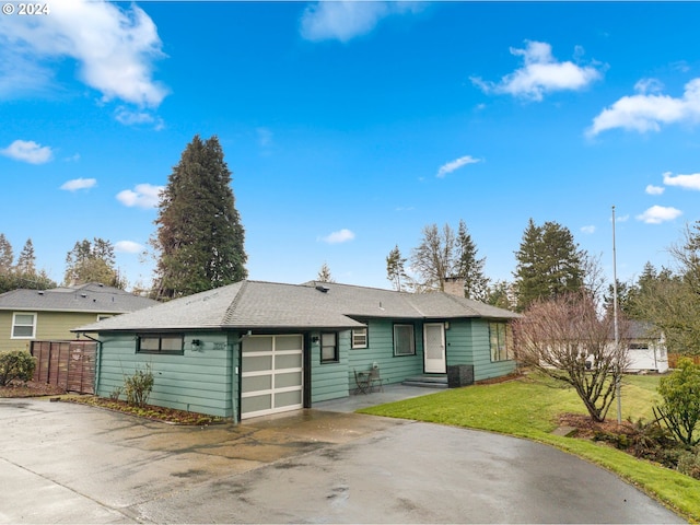 single story home featuring a front lawn and a garage