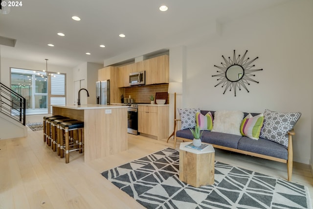 living room with light hardwood / wood-style flooring and sink