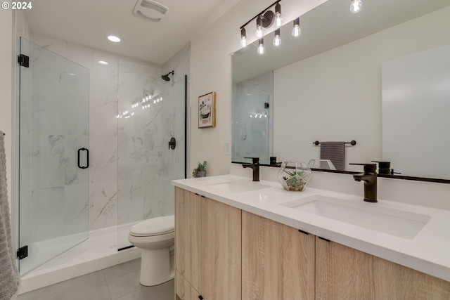 bathroom featuring double vanity, tile floors, toilet, and a shower with shower door