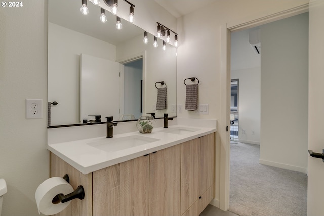 bathroom featuring dual sinks, oversized vanity, and toilet