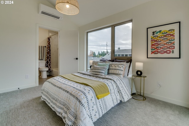 bedroom with an AC wall unit, connected bathroom, and carpet flooring