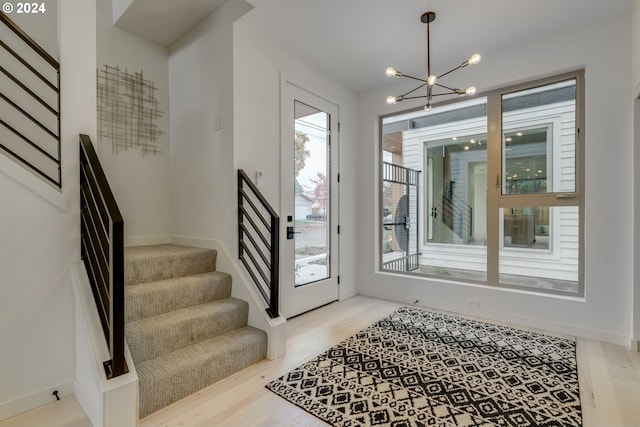 doorway featuring a notable chandelier and light hardwood / wood-style flooring