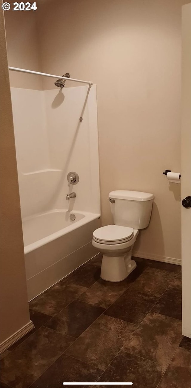 bathroom featuring washtub / shower combination and toilet