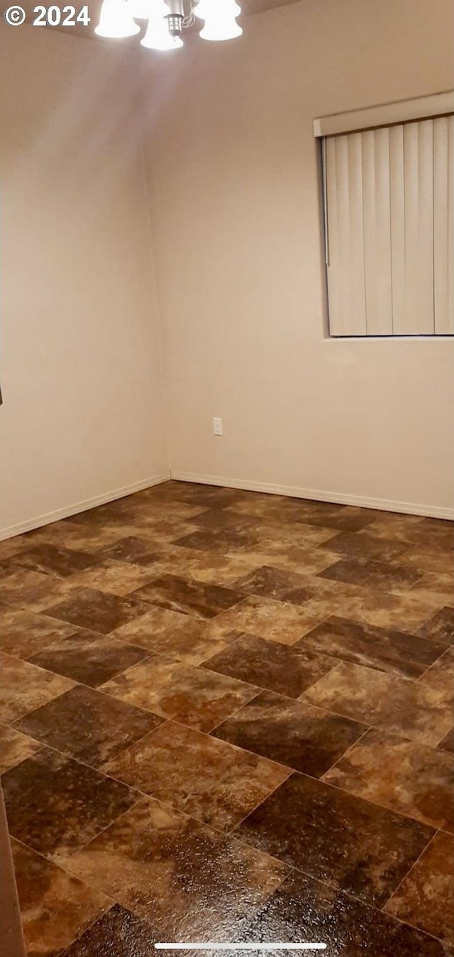 unfurnished room with an inviting chandelier