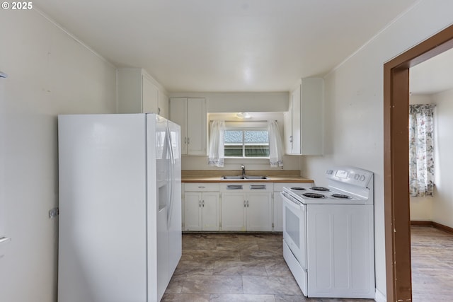 kitchen with white appliances, white cabinetry, light countertops, and a sink