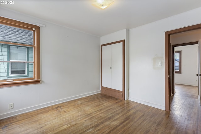 unfurnished bedroom with hardwood / wood-style flooring, baseboards, and ornamental molding