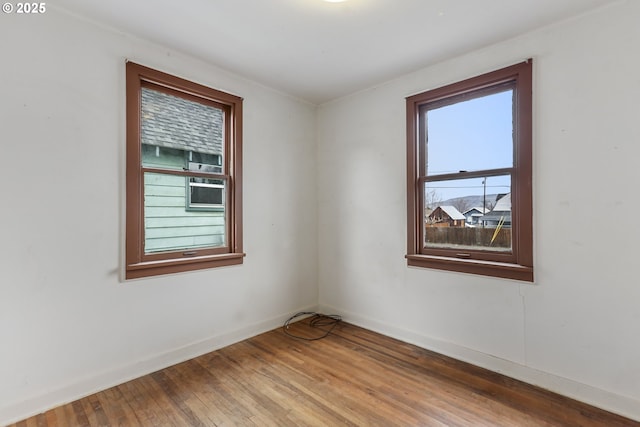 empty room featuring baseboards and wood-type flooring