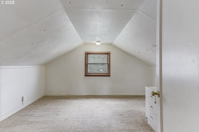 bonus room featuring carpet floors, a textured ceiling, baseboards, and vaulted ceiling