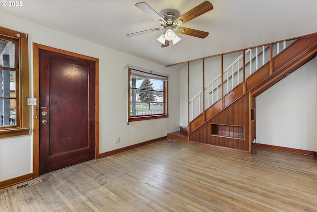 foyer with visible vents, a ceiling fan, wood finished floors, stairway, and baseboards