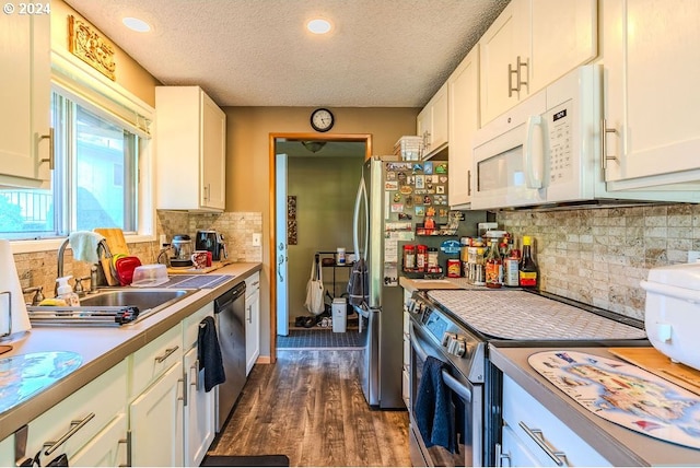 kitchen featuring white cabinets, backsplash, stainless steel appliances, a textured ceiling, and dark hardwood / wood-style floors