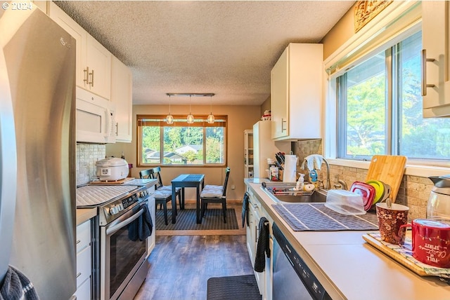 kitchen featuring stainless steel appliances, plenty of natural light, and white cabinetry