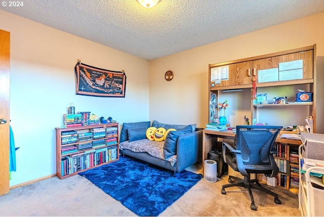 carpeted home office featuring a textured ceiling