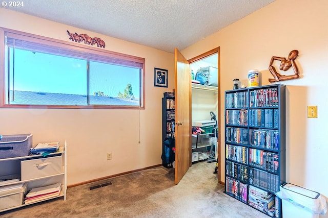 office space with a textured ceiling and carpet flooring