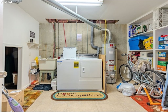 interior space with gas water heater, washer and dryer, and sink