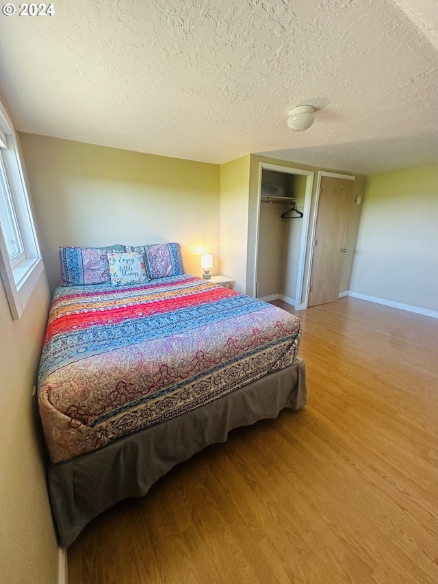 bedroom featuring a textured ceiling, a closet, and hardwood / wood-style flooring