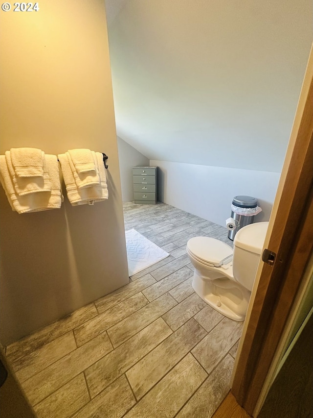 bathroom featuring toilet and lofted ceiling