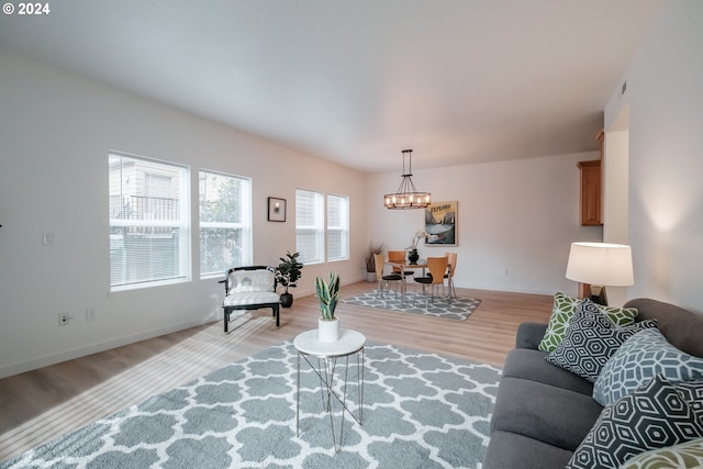 living room with light hardwood / wood-style flooring and a notable chandelier