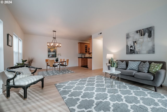 living room featuring light hardwood / wood-style floors and an inviting chandelier