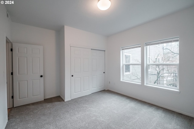 unfurnished bedroom featuring carpet flooring and a closet