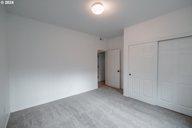 unfurnished bedroom with carpet flooring and a closet