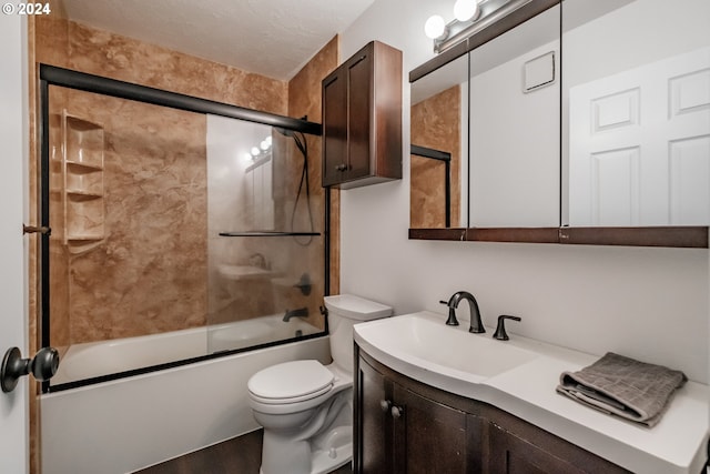 full bathroom with bath / shower combo with glass door, a textured ceiling, vanity, hardwood / wood-style flooring, and toilet