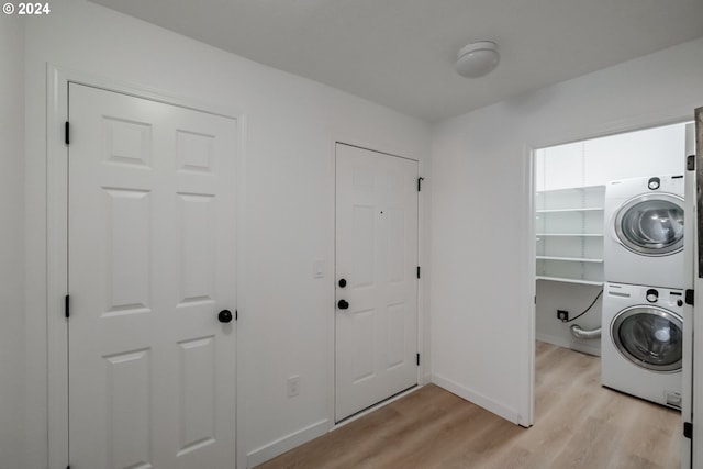 clothes washing area with light hardwood / wood-style floors and stacked washer and clothes dryer