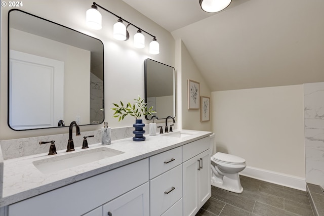 bathroom with vanity, lofted ceiling, toilet, and tile patterned floors