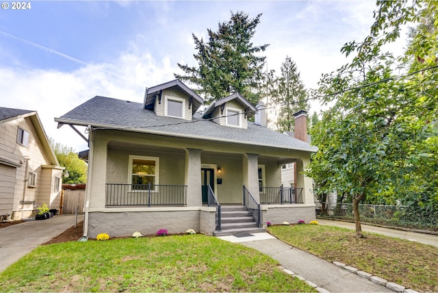 bungalow with a porch and a front yard