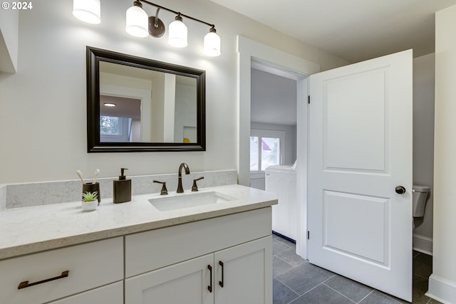 bathroom featuring vanity, toilet, washer / dryer, and tile patterned floors