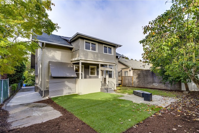 back of house featuring a lawn