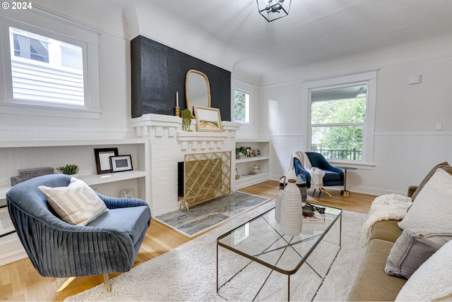 living room featuring wooden walls, wood-type flooring, and built in features