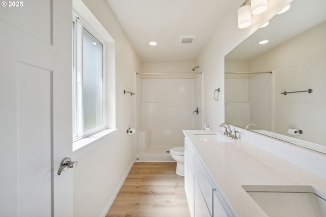655 11th St SW, Bandon, OR 97411 - bathroom featuring toilet, a shower, wood finished floors, double vanity, and recessed lighting
