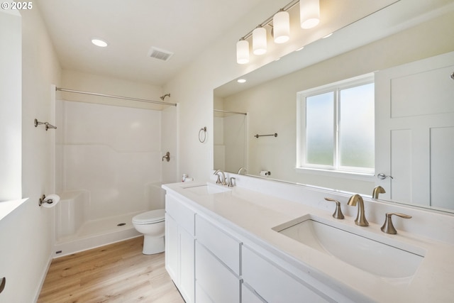 655 11th St SW, Bandon, OR 97411 - full bath with wood finished floors, toilet, a shower, double vanity, and recessed lighting