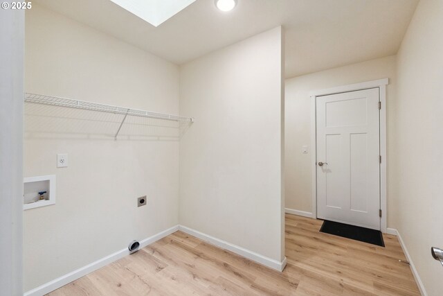 655 11th St SW, Bandon, OR 97411 - washroom with electric dryer hookup, light wood-style flooring, a skylight, washer hookup, and baseboards